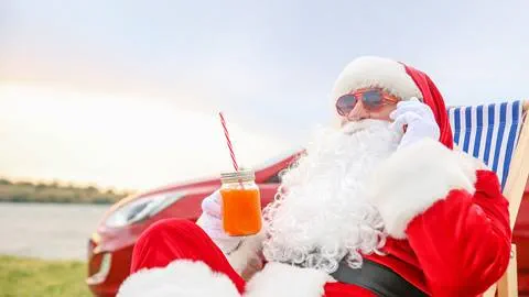 Santa sitting in a lawn chair in the summer drinking a cold beverage.