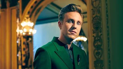 Professional portrait of musician Cody Fry wearing green suit.
