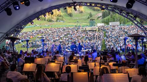 View of the audience standing on the stage of the Deer Valley Outdoor Amphitheater during a summer concert.