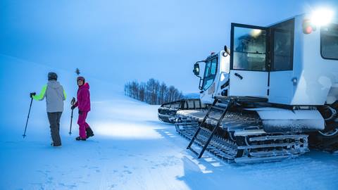 Skiers walking away from snowcat at Deer Valley