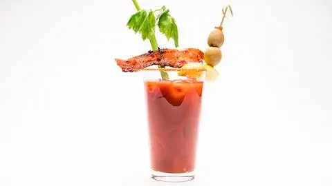 Bloody mary drink with celery, bacon, and peppers.