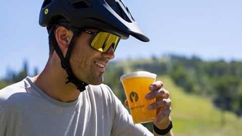 Guest wearing mountain biking gear is drinking beer.