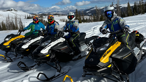 Guests snowmobiling through snowy Wasatch backcountry on an Adventourage guided tour