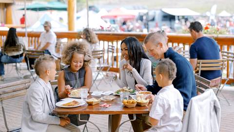 Family eating lunch on the deck at Deer Valley Resort during the summer.