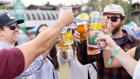 Group of friends do a cheers with beer at Deer Valley Mountain Beer Festival in Park City, Utah.