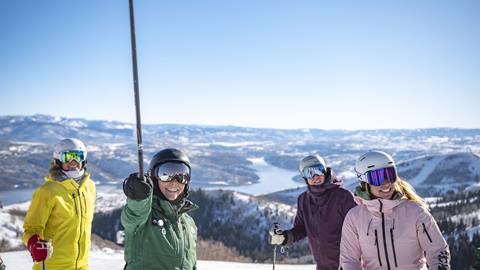 Deer Valley Mountain Host pointing to terrain to show group of skiers during Mountain Host Tour.