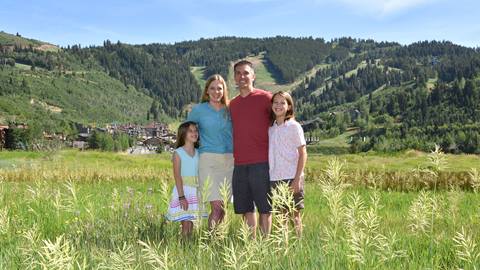 Family of four portrait with mountains in background