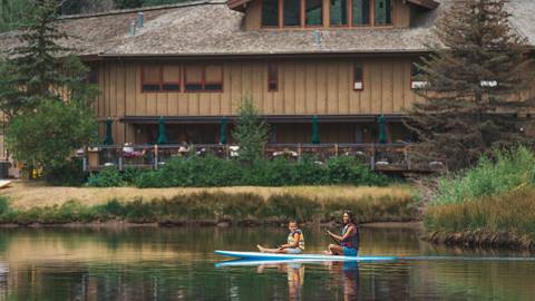 Mother and son stand up paddleboarding at Deer Valley's Pebble Beach.
