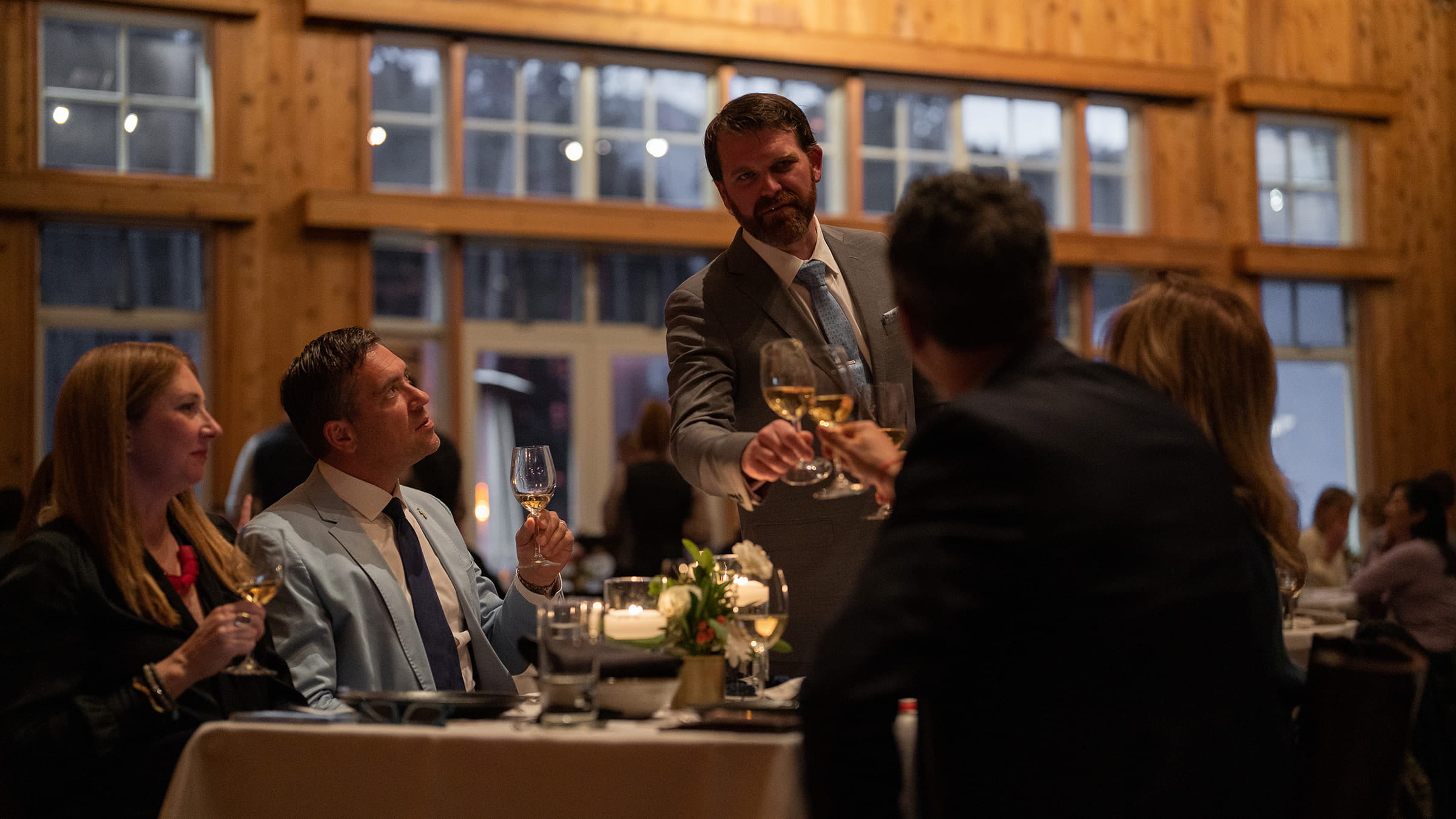 Group of people clinking glasses as a fine dining event. 