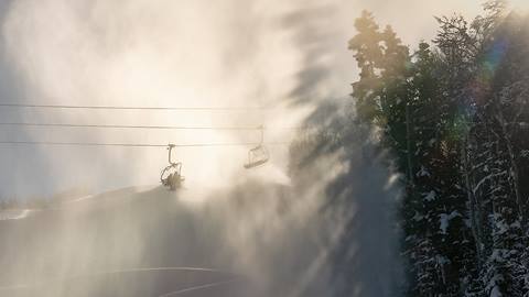 Image of chairlift with snow blowing