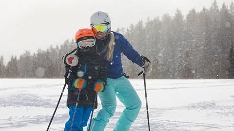 Mother and son skiing together.