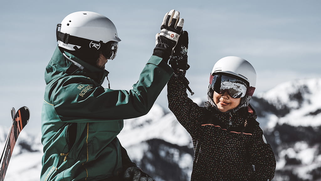 Ski Instructor High-Fives Student
