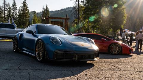 Blue sports car at car festival with sunset in background