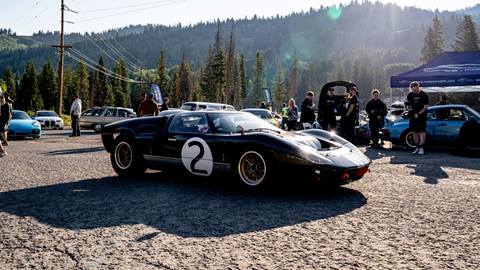 Black sports car at car festival with sunset in background