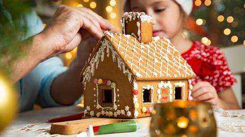 Family decorating gingerbread house.