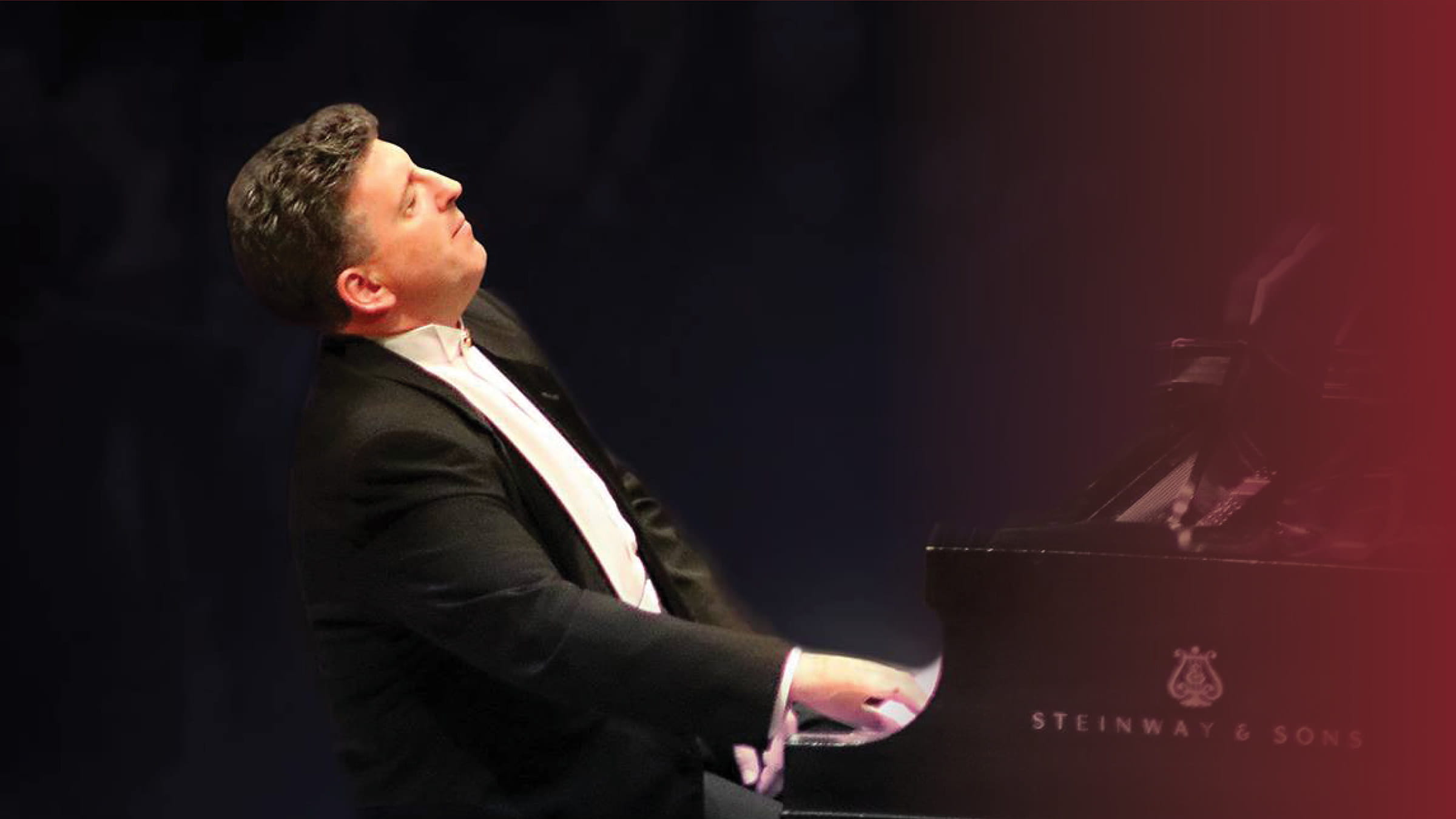 Man wearing concert attire playing piano