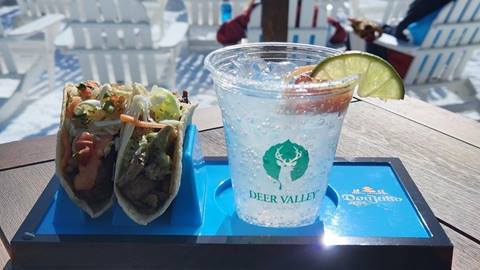 Tacos and a beverage displayed on a table outside.
