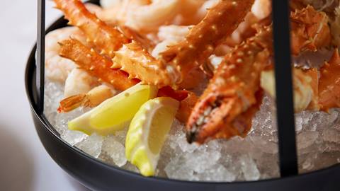 Crab legs served with lemon on ice.