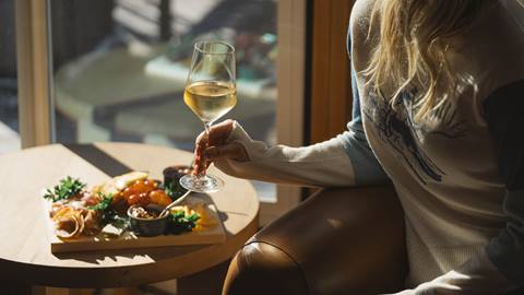 Woman with charcuterie board and wine in Chute Eleven après-ski yurt at Deer Valley.