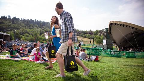 Couple holding gourmet picnic bags at a Deer Valley summer concert.