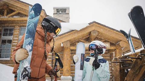 Mother and daughter carrying skis outside Cushing's Cabin at Deer Valley.