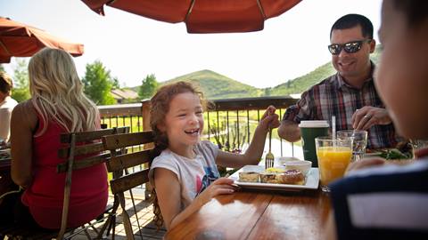 Girl eating lunch with her family on the deck at the Deer Valley Café. 