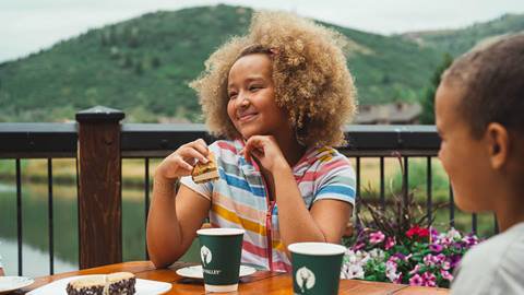 Girl and boy eating ice cream sandwiches on the deck at Deer Valley Café in the summer.