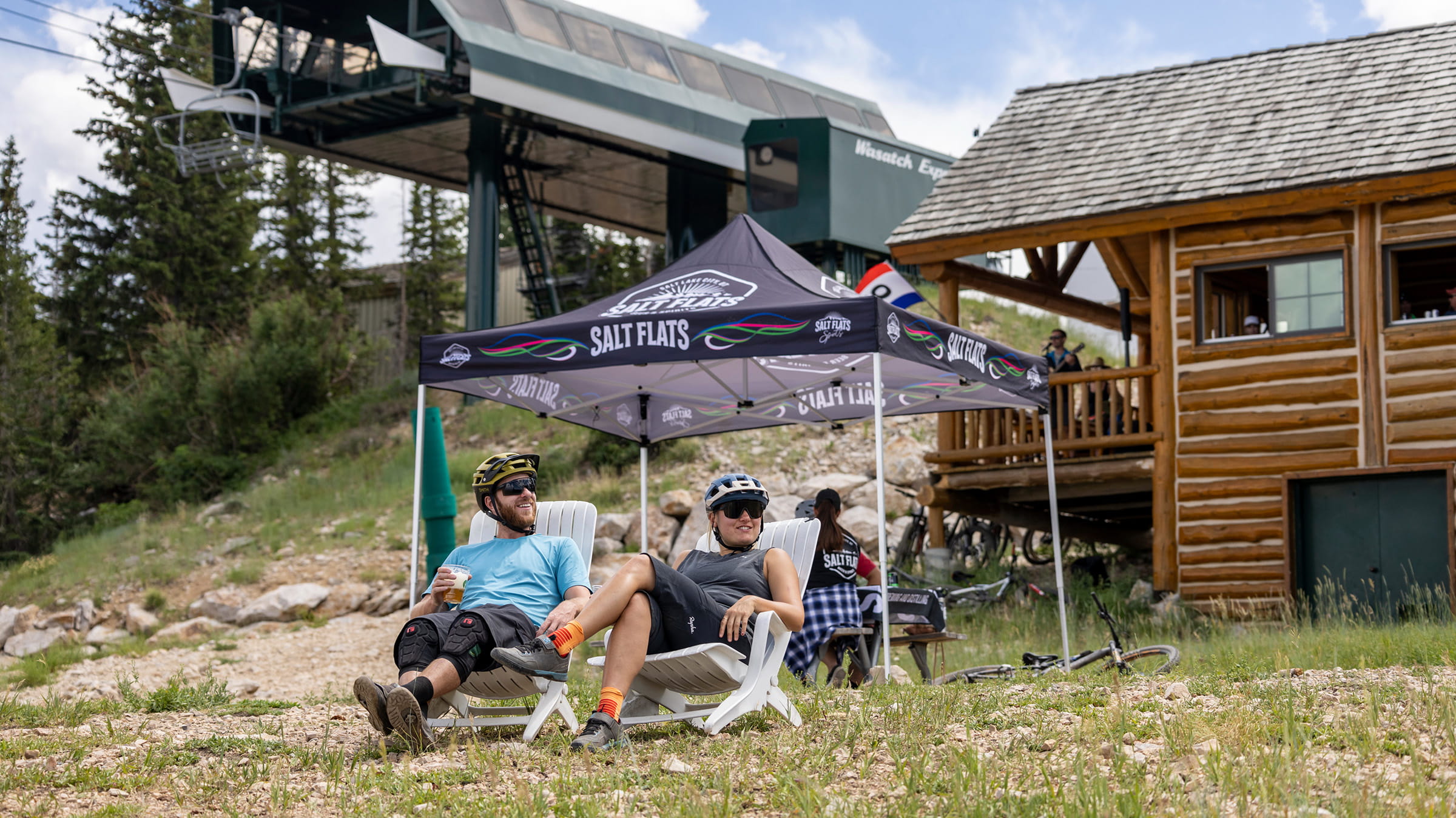 Guests sitting outside in lawn chairs drinking beer.