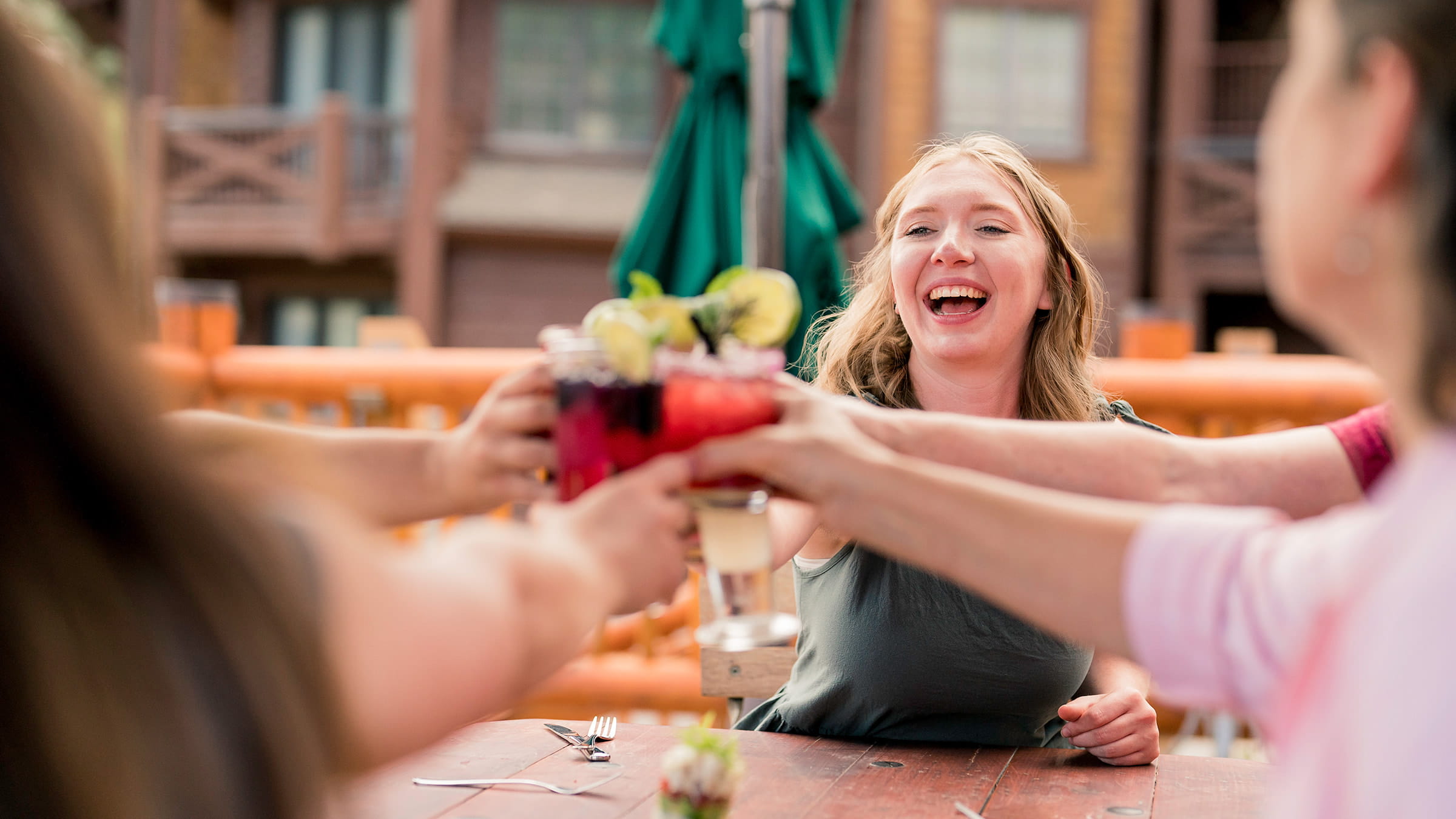 Group of friends clinking summer cocktails on the deck.