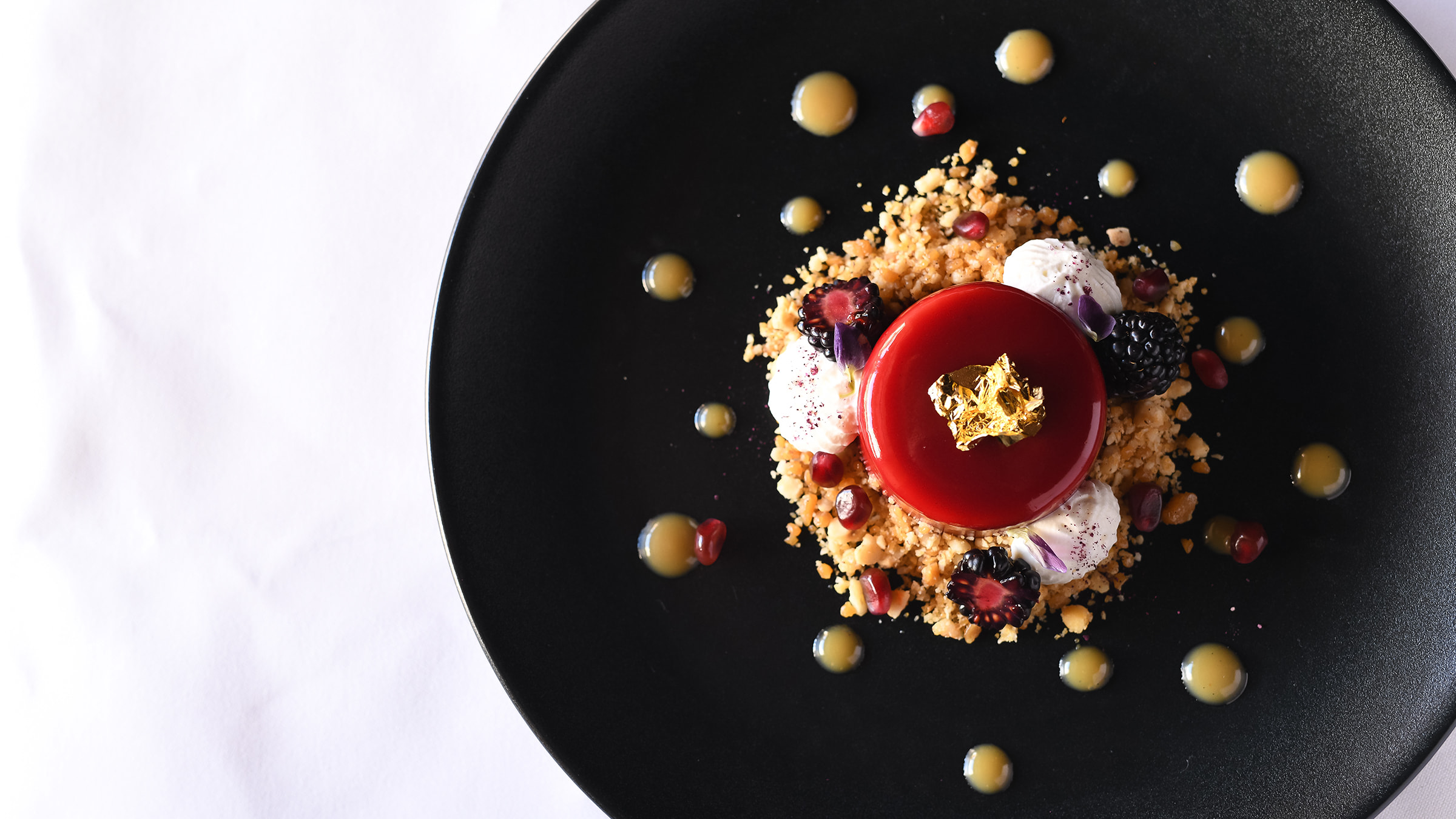 Fruit dessert beautifully displayed on a black plate.