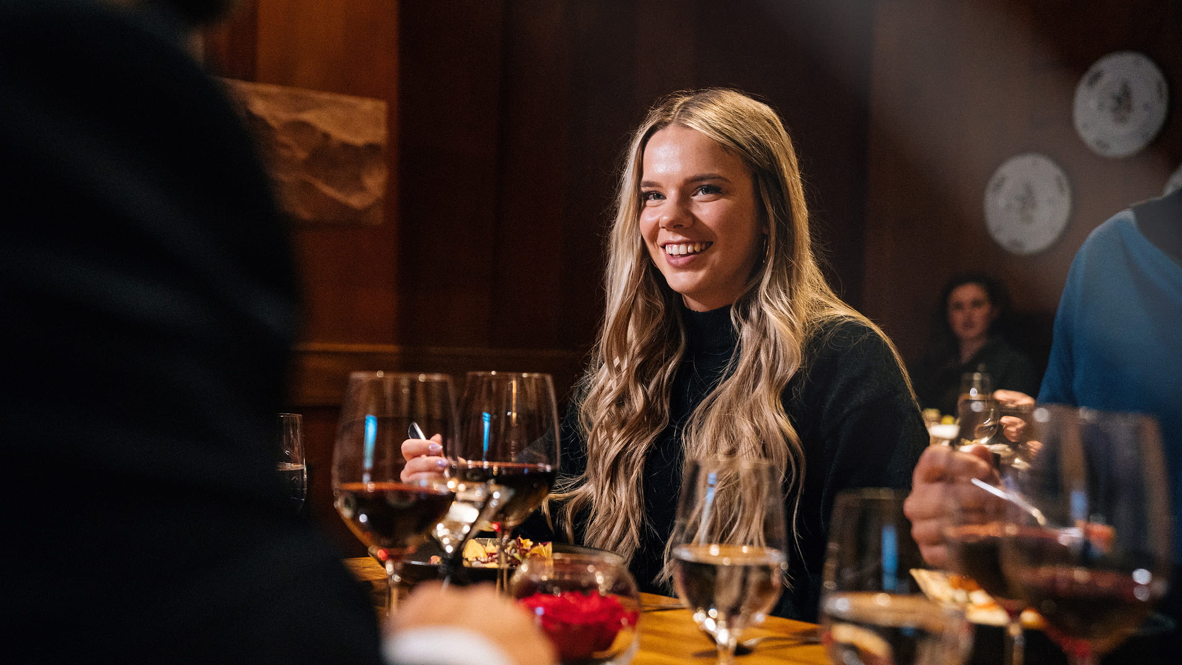 Woman smiling while holding a fork at the Mariposa restaurant.