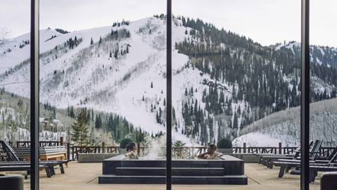 Couple in hot tub with mountain views at luxury lodging property in Park City, Utah.