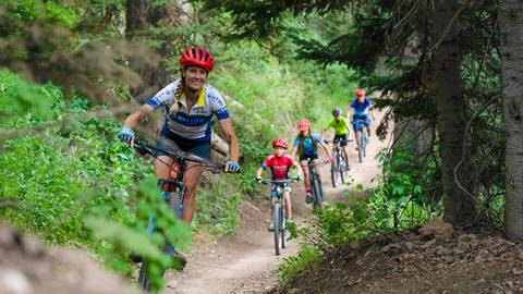 A family biking through the trees at Deer Valley.