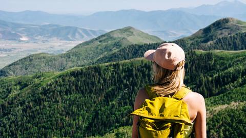 Woman with yellow backpack hiking at Deer Valley in the summer.