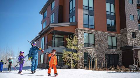 Deer Valley lodging guests leaving ski-in/ski-out property with skis.