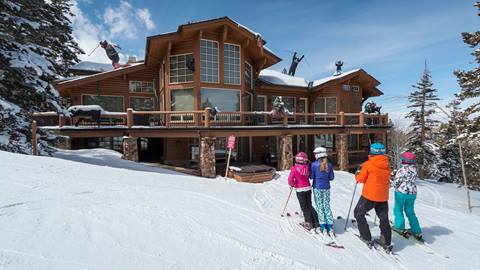 Family wearing skis standing outside a lodge at Deer Valley.