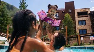 Little girl playing in the pool with her family.