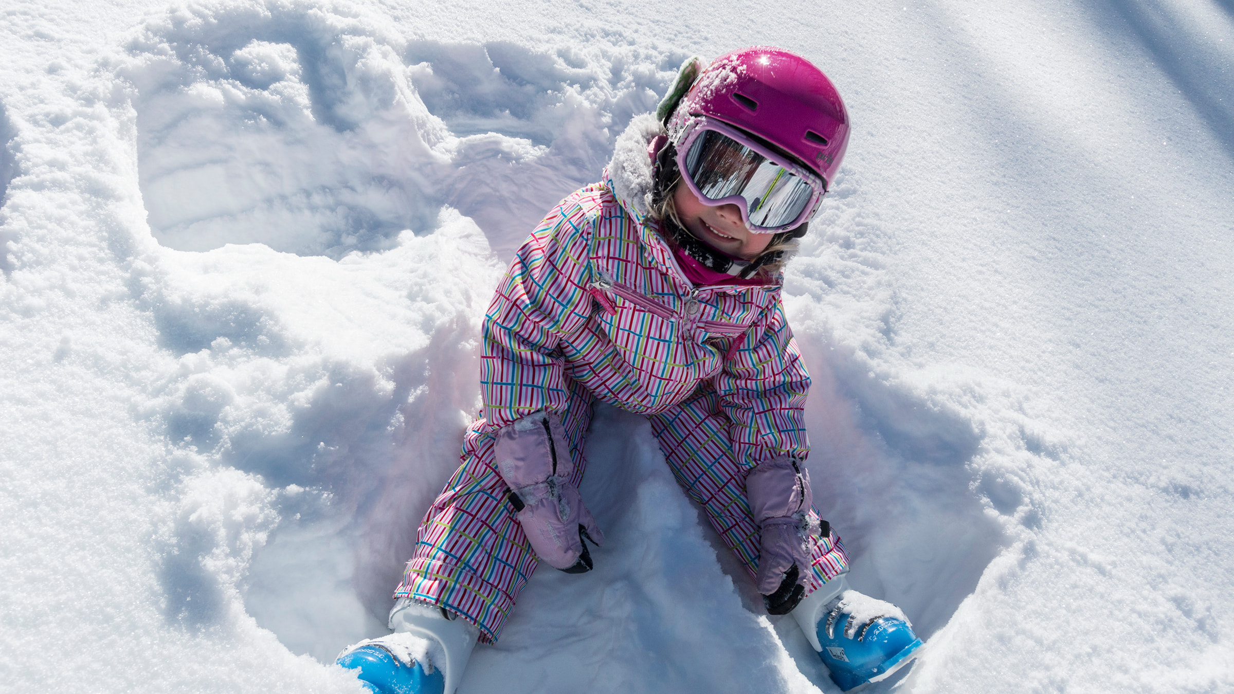 Little girl sitting in the snow.