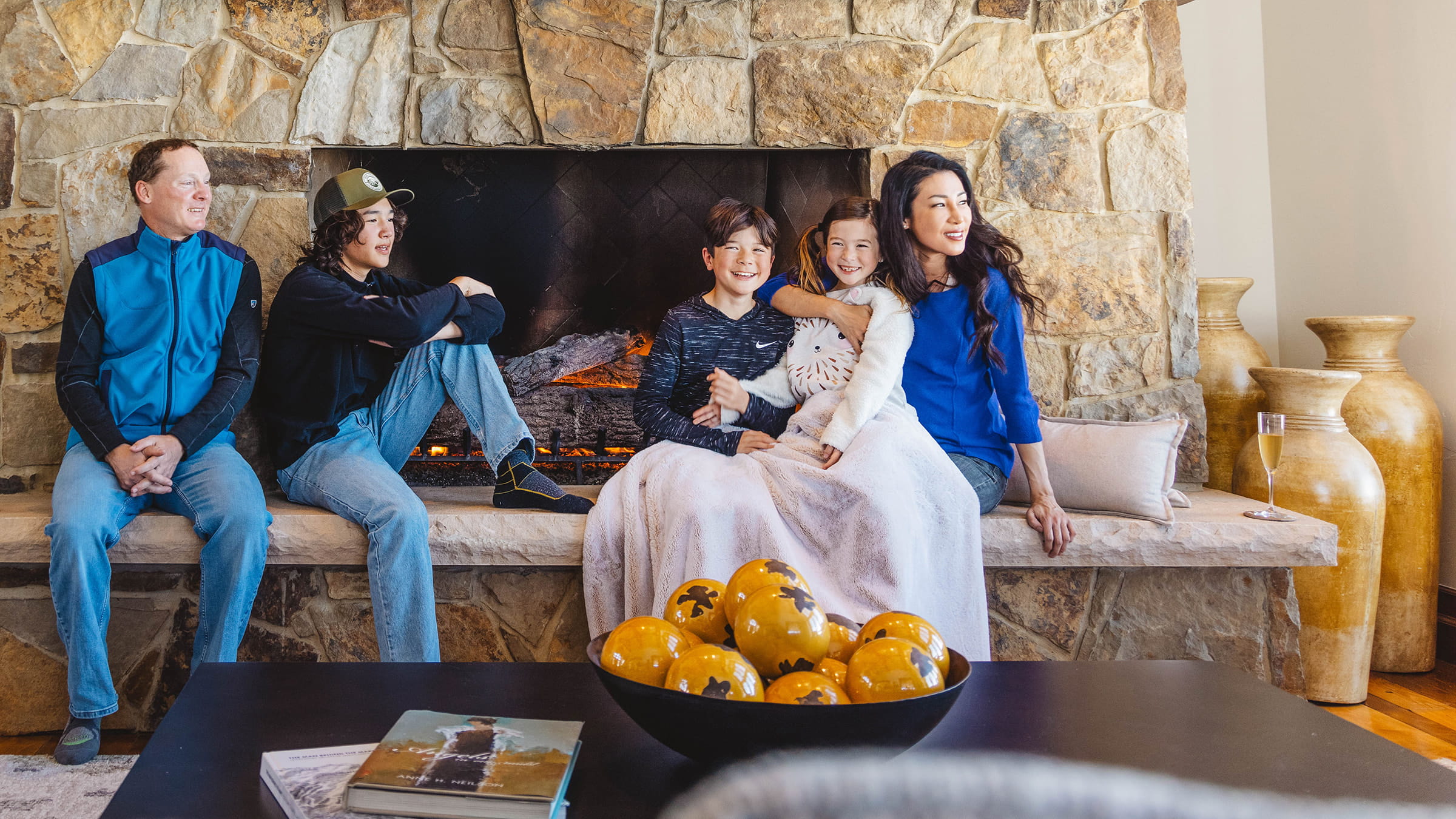 Family sitting by fireplace.