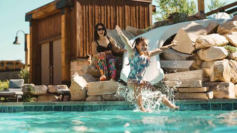 Mother watching daughter on waterslide at Deer Valley lodging property in the summer.