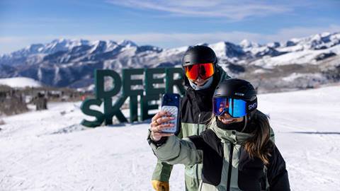 Skiers taking a selfie with Deer Skiers sign at Deer Valley Resort.