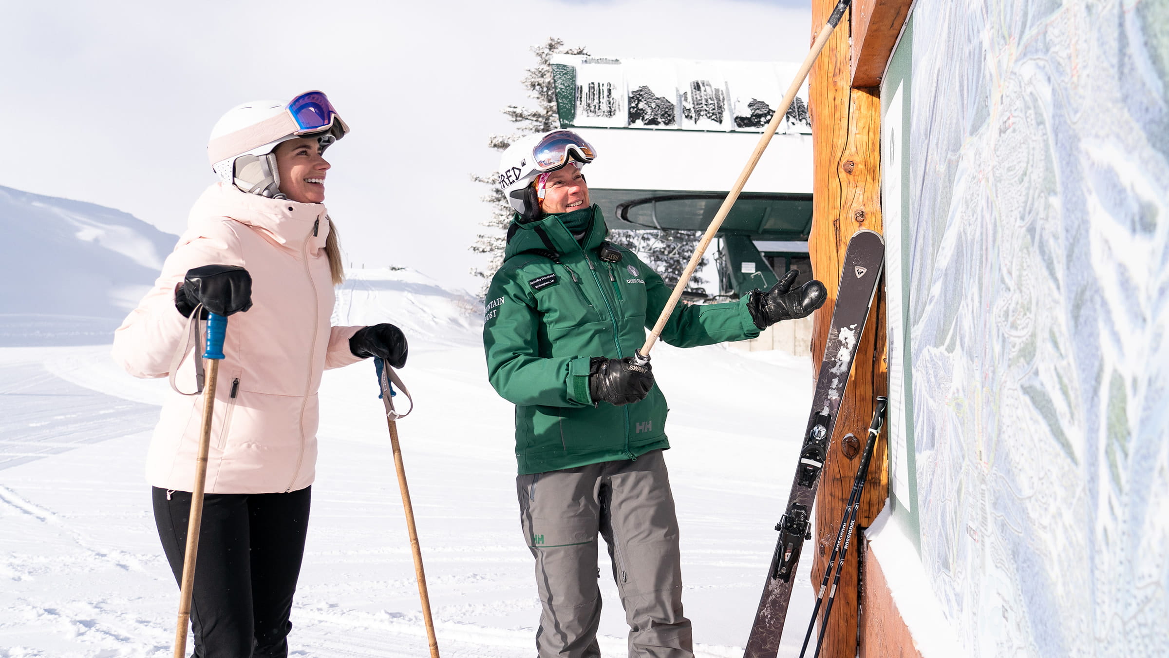 Female mountain host showing guest where they are located on the trail map.
