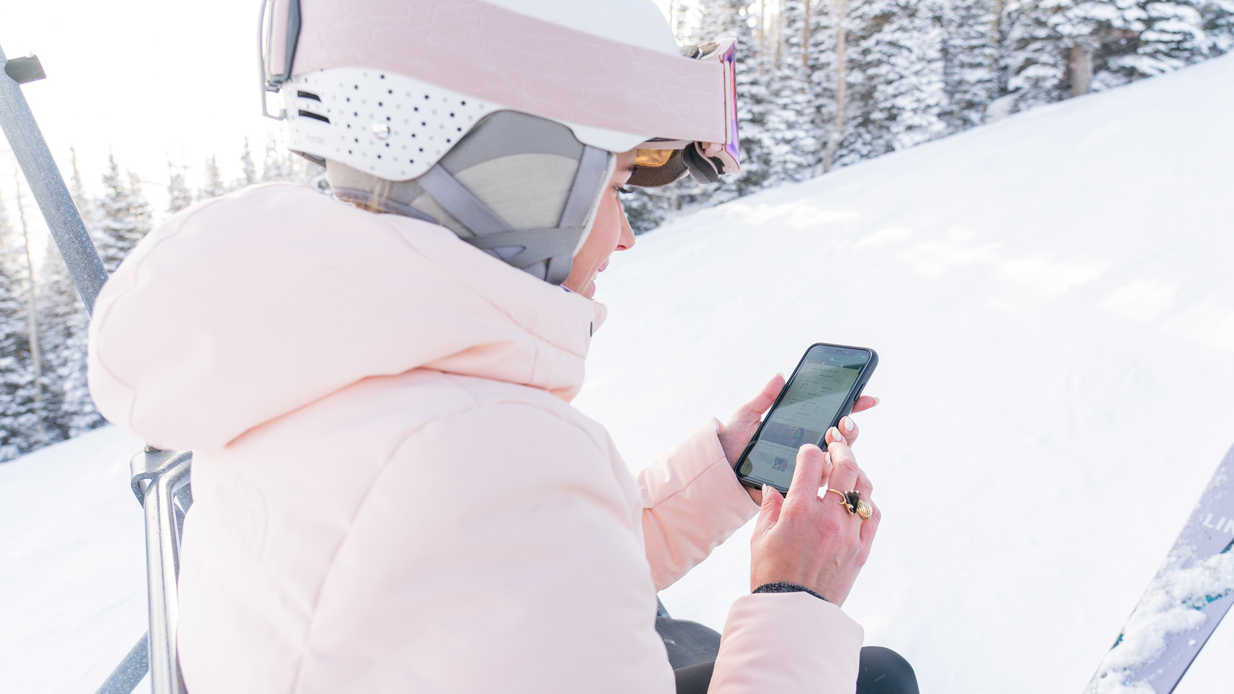 A skier using their phone to download the Deer Valley mobile app.