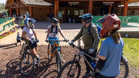 Girls with mountain bikes talking with Deer Valley Bike Instructor at Snow Park Lodge