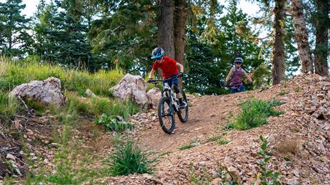 Girl watching boy bike down a hill at Deer Valley.