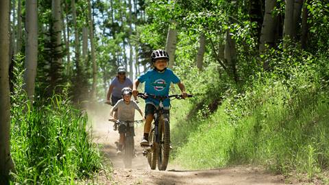 Young boy mountain biking with his family at Deer Valley.