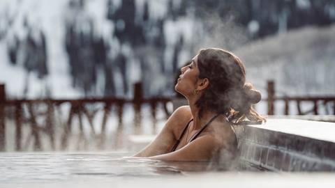 woman sitting in hot tub at deer valley during winter season