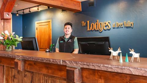 A staff member standing by the front desk at the Lodges at Deer Valley.