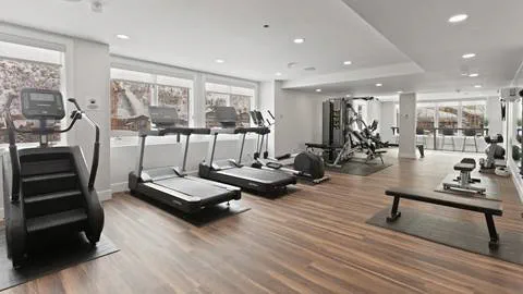 Trail's End Lodge fitness center, where various machines can be seen such as an eliptical, several treadmills, weights, etc.