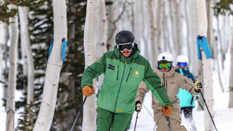 Deer Valley Ski Instructor and two students skiing through aspen trees.
